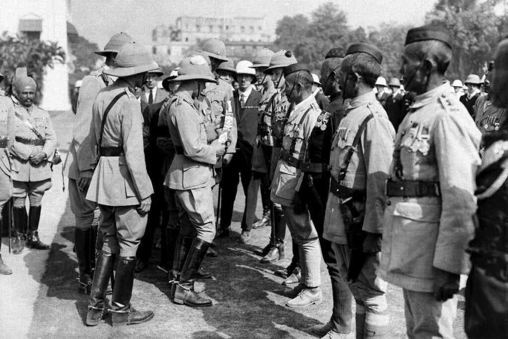 The Prince of Wales meeting decorated Gurkha officers in Calcutta, 1922, during a formal inspection ceremony. British colonial officers in pith helmets stand nearby.
